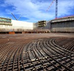 Two of the emblematic construction projects on the ITER platform in late 2013: a winding facility for the massive poloidal field coils (in red) and the Cryostat Workshop (at right).